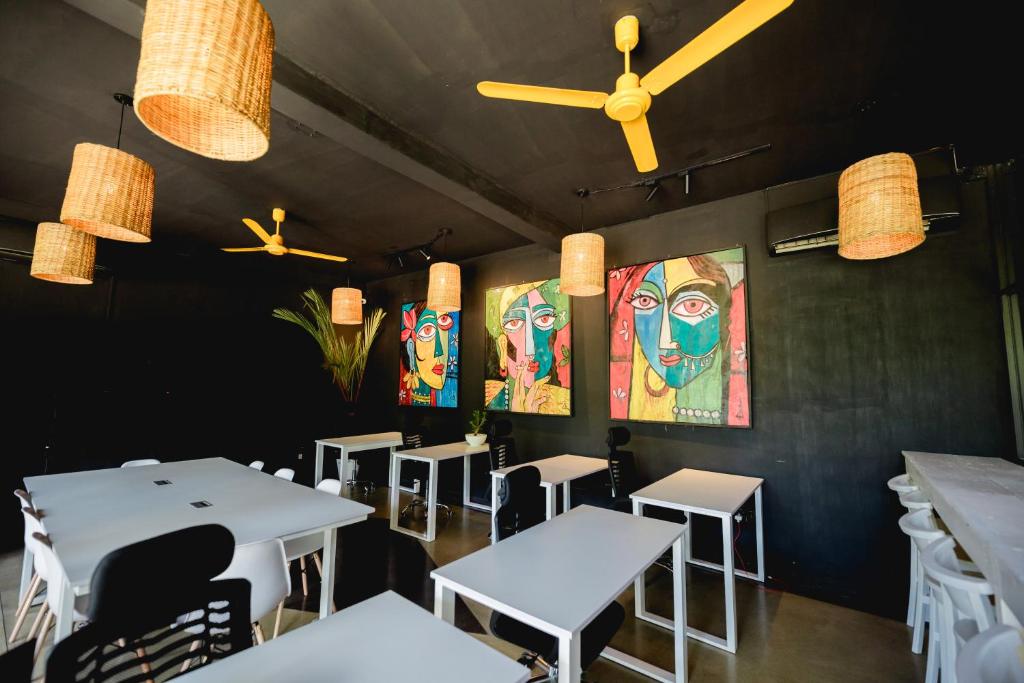 The main coworking room at Mellow Bay, with desks, ceiling fans and mural walls